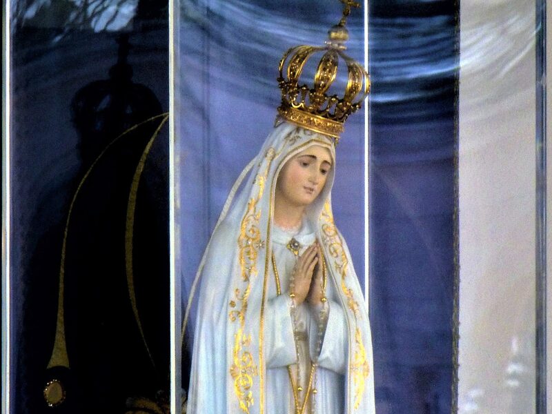 Imagen de la Virgen de Fátima coronada, con las manos juntas y el rosario, en la Capilla de las Apariciones